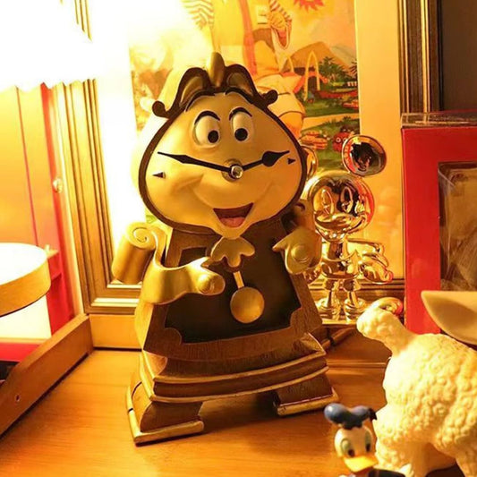 Animated Beauty and the Beast character clock with a gold finish on a wooden surface.