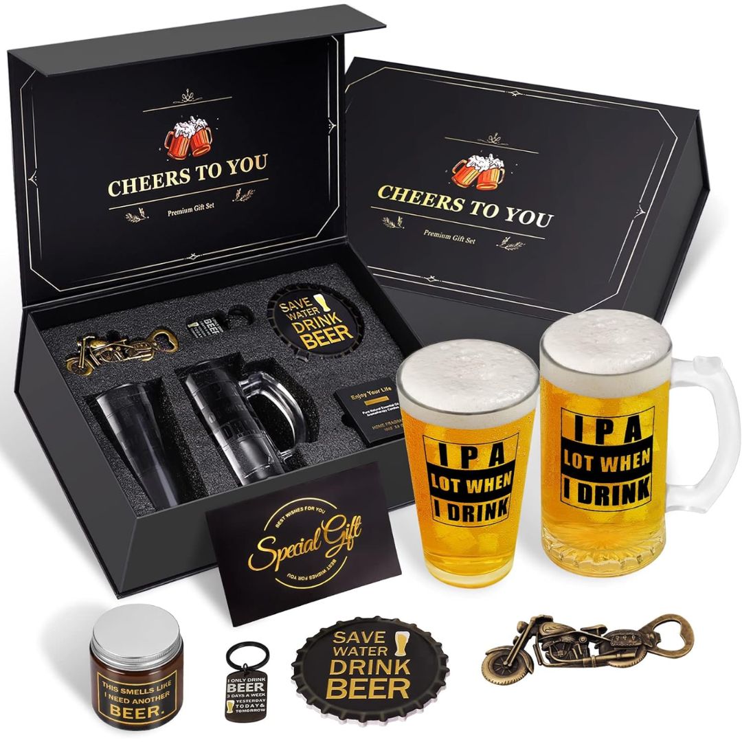 A beer-themed gift set displayed on a white background, including two frosted beer steins with 'IPA LOT WHEN I DRINK' text, a black presentation box with 'CHEERS TO YOU' printed inside, a bottle opener, a small jar, a coaster, and a keychain.