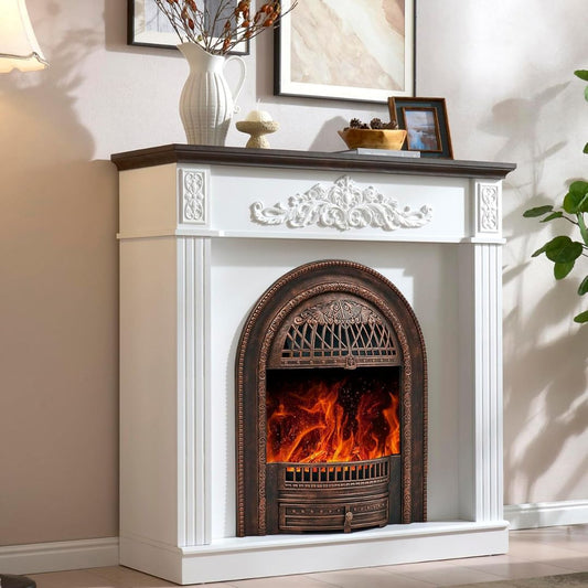 A white electric fireplace mantel with a dark wood mantel and a bronze-finished firebox insert showing a glowing fire, set in a styled living room interior.