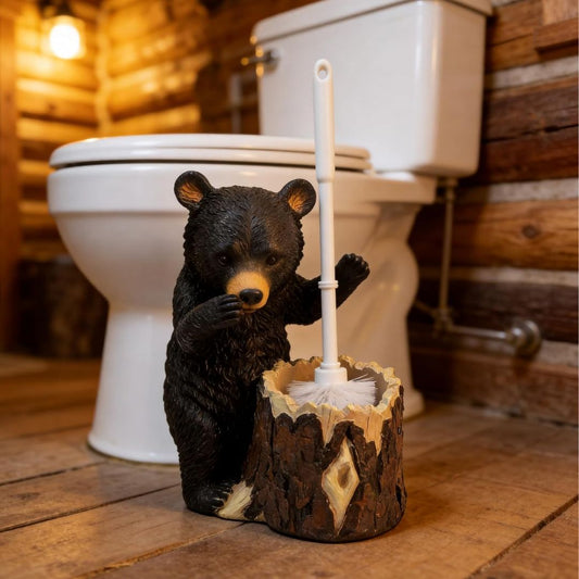 Bear-shaped toilet brush holder on a wooden floor with a toilet in the background.