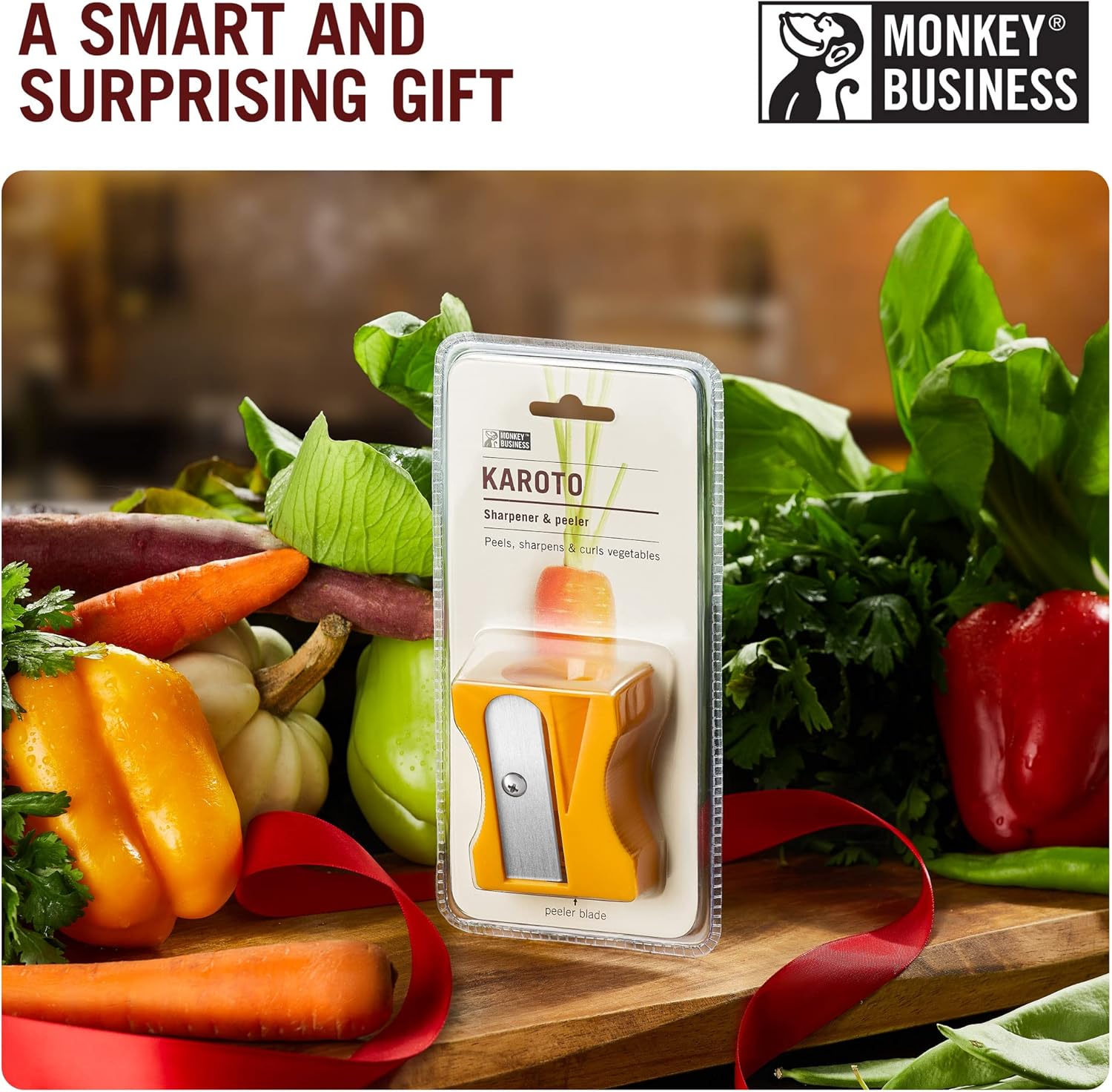 Packaged yellow Karoto carrot sharpener displayed among fresh vegetables, positioned as a fun and unique gift idea.