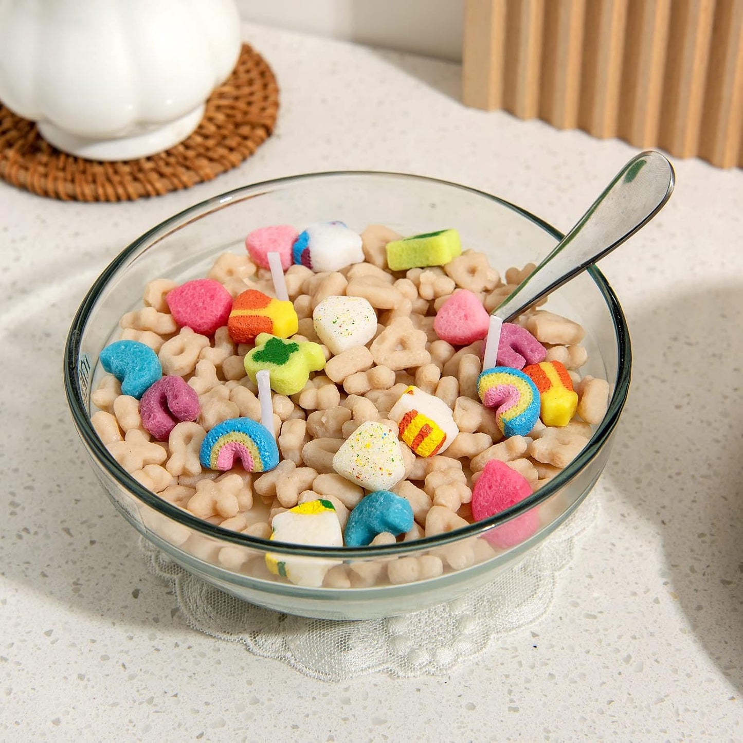 Bowl of cereal that looks like a candle with colorful candy pieces on a light surface