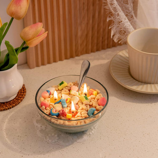 Bowl of cereal with lit candles on a table with a cup and tulips in the background