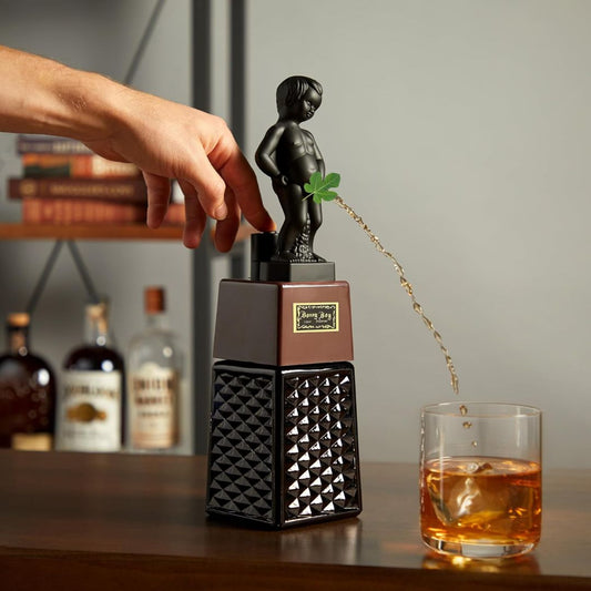 Novelty boy statue liquor dispenser being used on a home bar to pour whiskey into a glass with ice