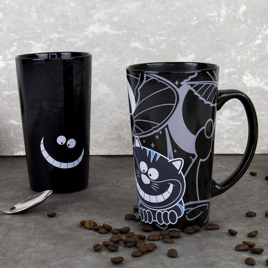 Heat changing black mugs with a Cheshire cat and smiley face designs on a gray surface with coffee beans.
