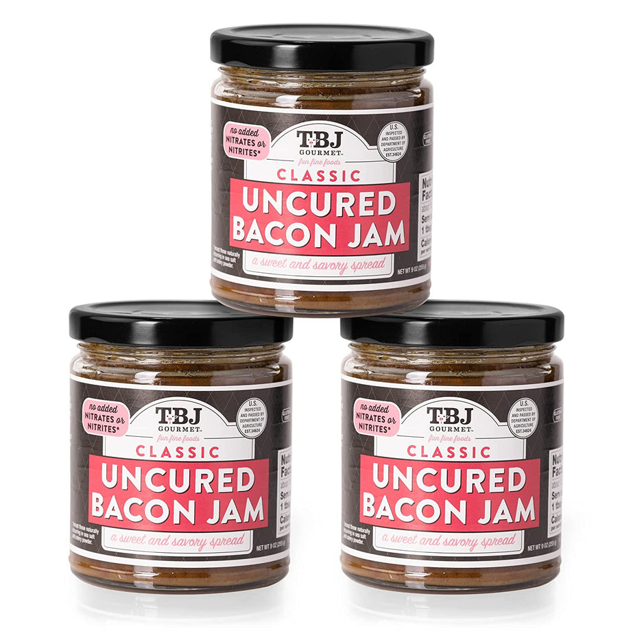 Three glass jars of classic uncured bacon jam with black lids and pink and white labels