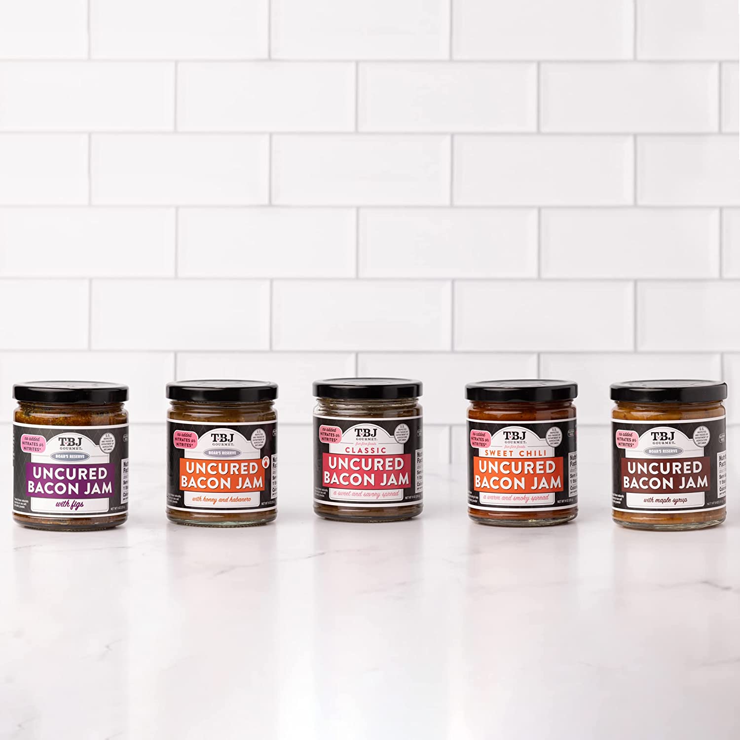 Five jars of different flavored bacon jams.