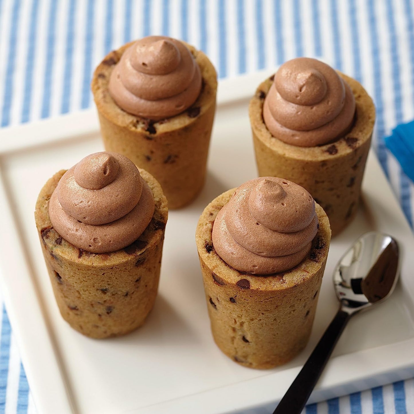 Four cookie shot glasses filled with chocolate mousse.