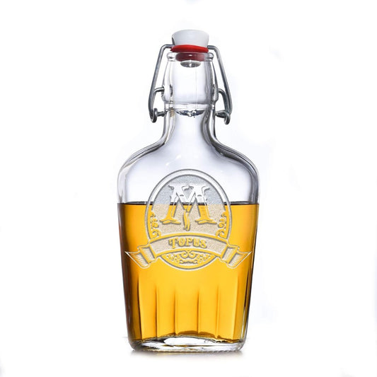 Custom engraved glass bottle with yellow liquid and a red cap on a white background