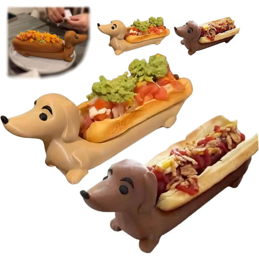 A novelty hot dog holder shaped like a dachshund dog, shown in two color variants (tan and brown) holding stuffed hot dogs. The image includes a small inset in the top-left corner showing a person holding a hot dog in the holder, which classifies the subject_type as Lifestyle due to the presence of a person/body part.