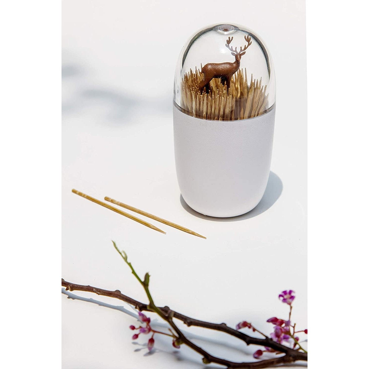 A toothpick holder which looks like a brown deer is hiding in a field of wheat.