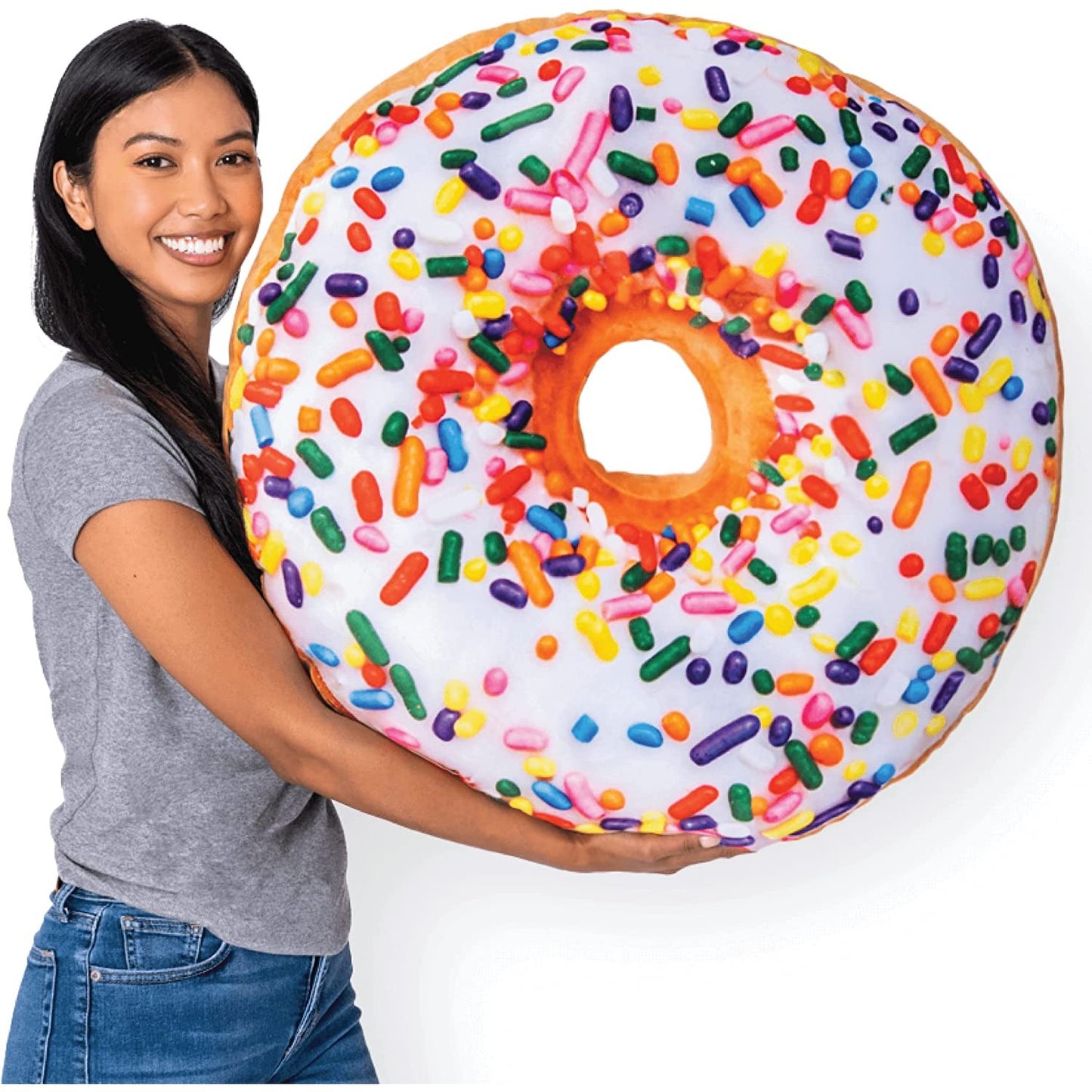 A woman is holding a colorful donut shaped pillow.
