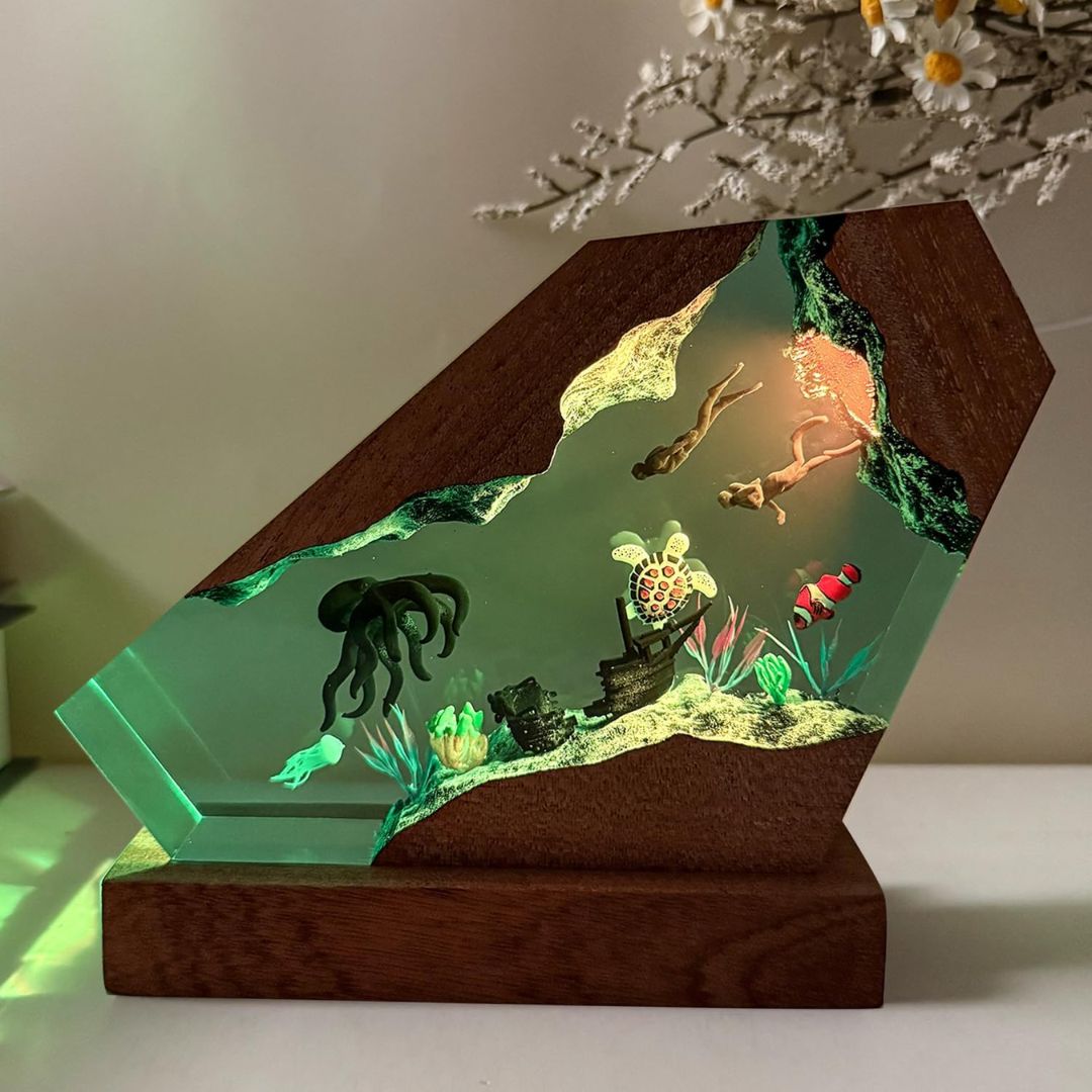 Epoxy resin aquarium-style night light with marine life figures on a light grey surface.