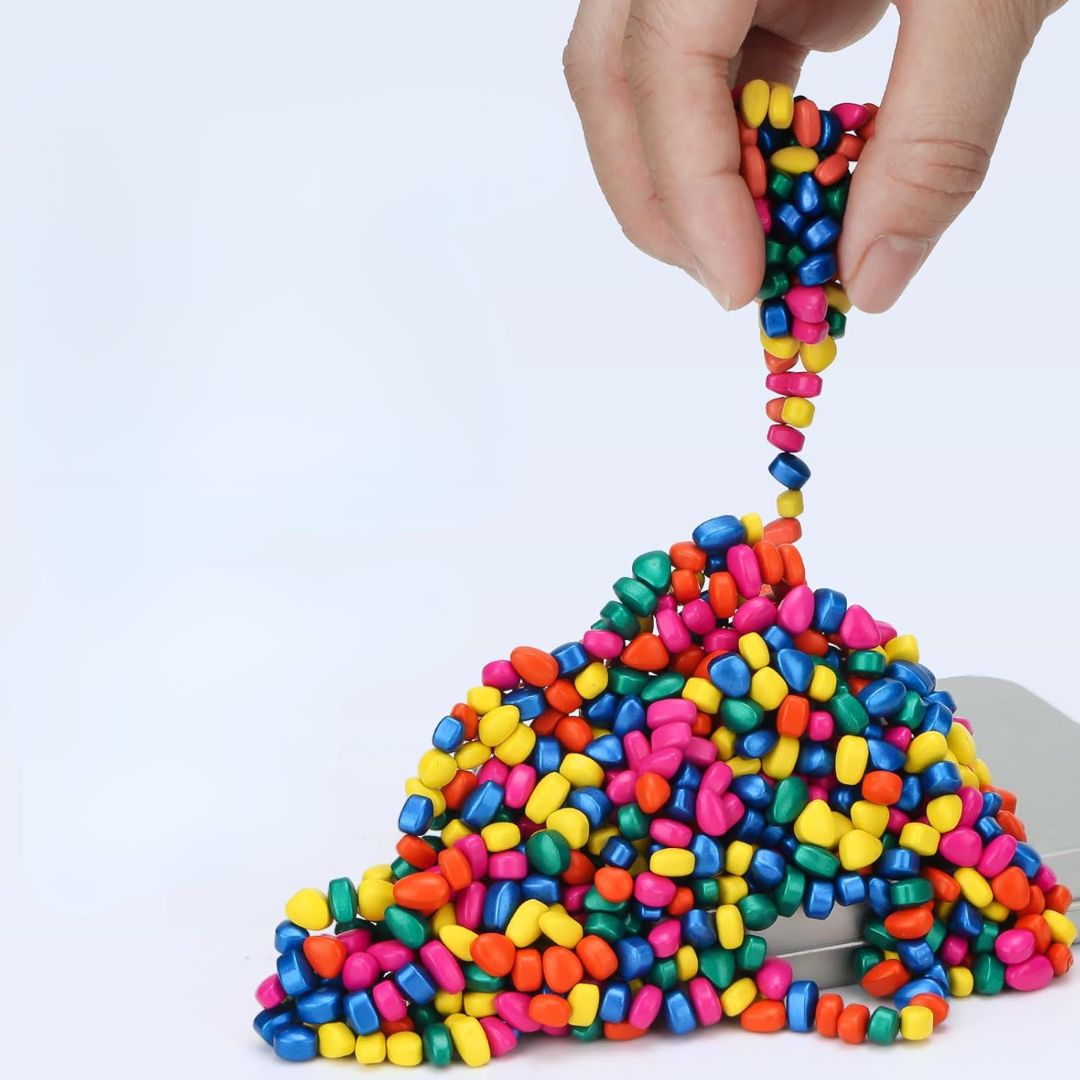 Colorful ferrite putty slime being stretched by a hand on a white background