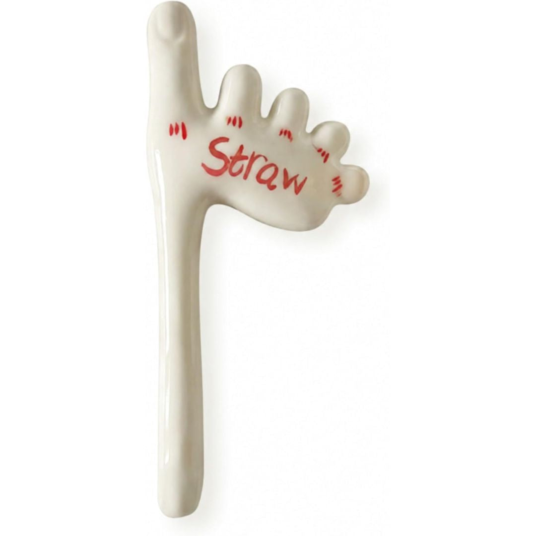 A ceramic novelty drinking straw shaped like a foot with the word 'Straw' written in red on the foot, shown on a plain white background.