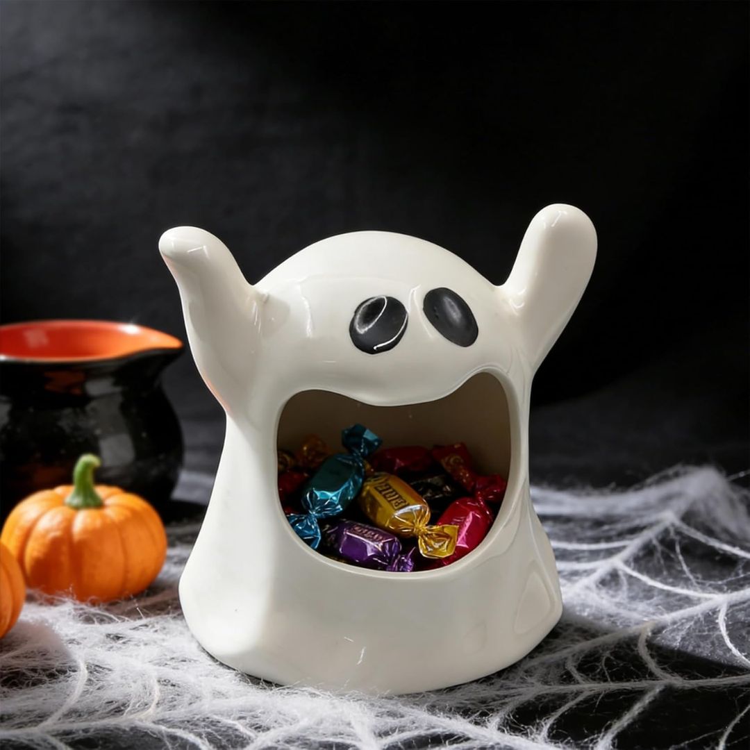 White ghost-shaped candy holder with colorful candies on a Halloween-themed background