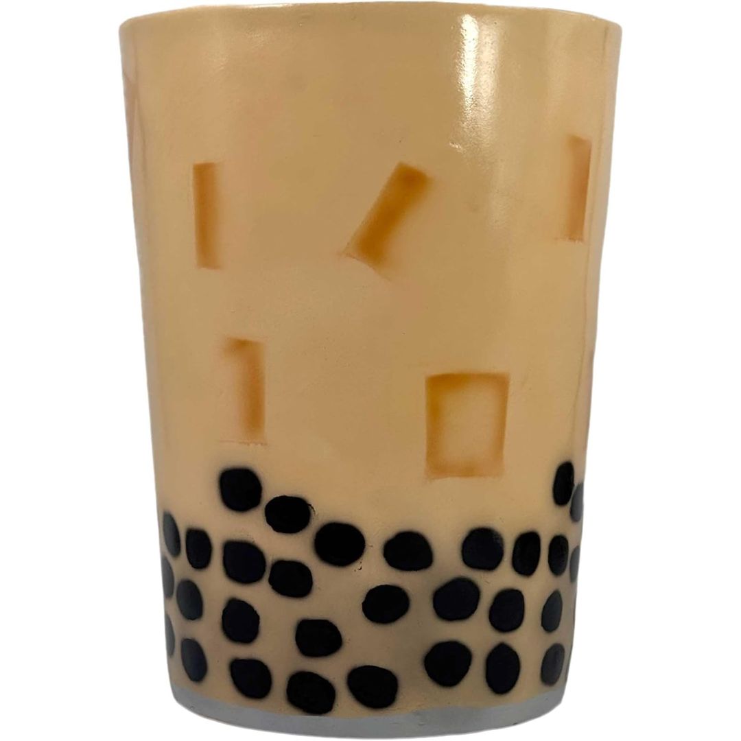 A giant novelty side table designed to look like a cup of bubble tea, featuring a beige body with ice cube details and black bubble dots along the bottom, set against a plain white background.