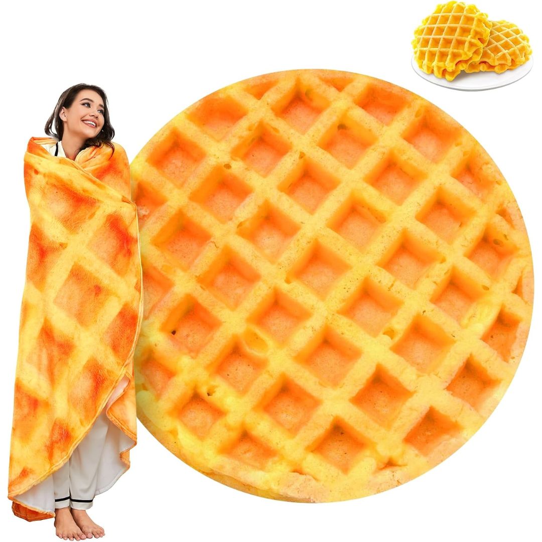 A person wrapped in a large waffle-print blanket shown beside a circular close-up of the waffle pattern and a small inset of waffles on a plate. The background is plain white.