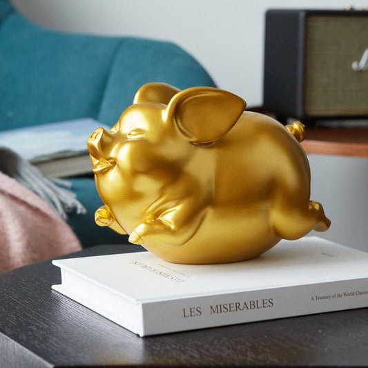 Gilded gold flying piggy bank on a book in a lounge room
