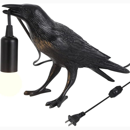 Black crow-shaped lamp with a visible power cord on a white background