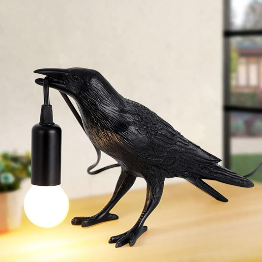 Black crow figurine holding a light bulb in mouth on a neutral background