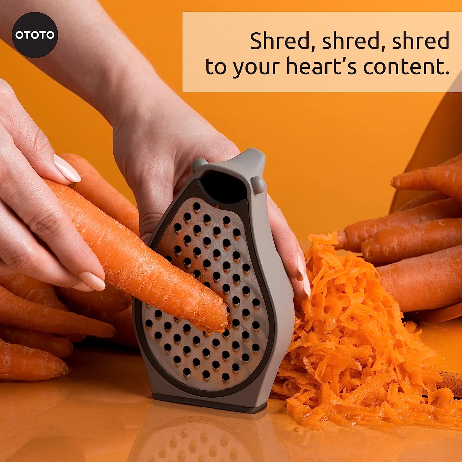 A person is shredding a carrot using a bear-shaped grater.