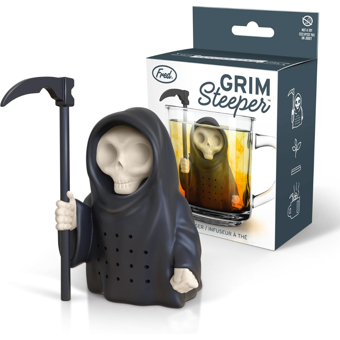 A black silicone Grim Reaper tea infuser with a scythe, next to its packaging labeled "Grim Steeper," showing the infuser in a glass cup of tea.A black silicone Grim Reaper tea infuser with a scythe, next to its packaging labeled "Grim Steeper," showing the infuser in a glass cup of tea.