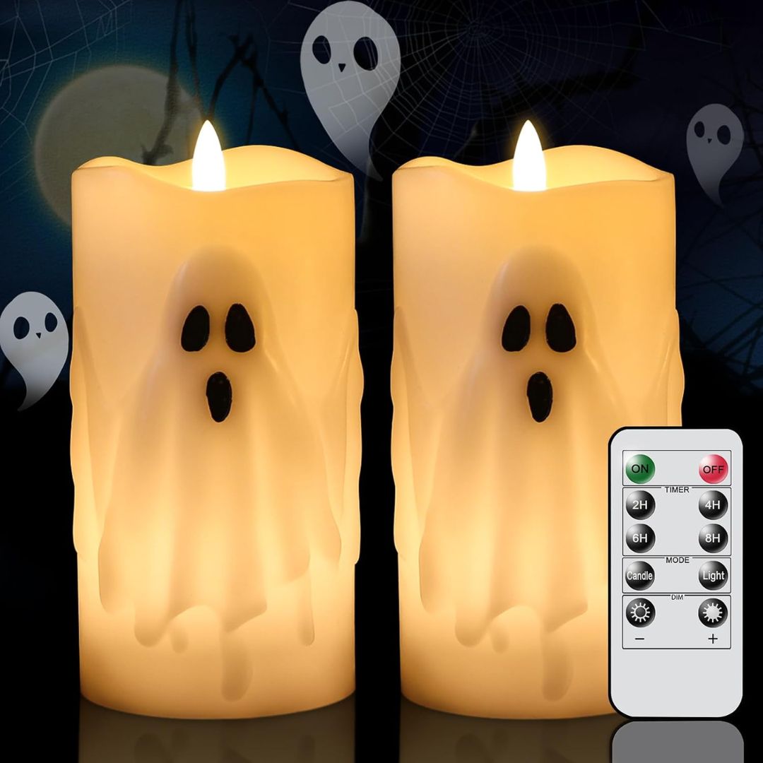 Two glowing ghost-shaped flameless pillar candles with black eyes and mouths, shown side by side with a white remote control on a dark Halloween-themed background.