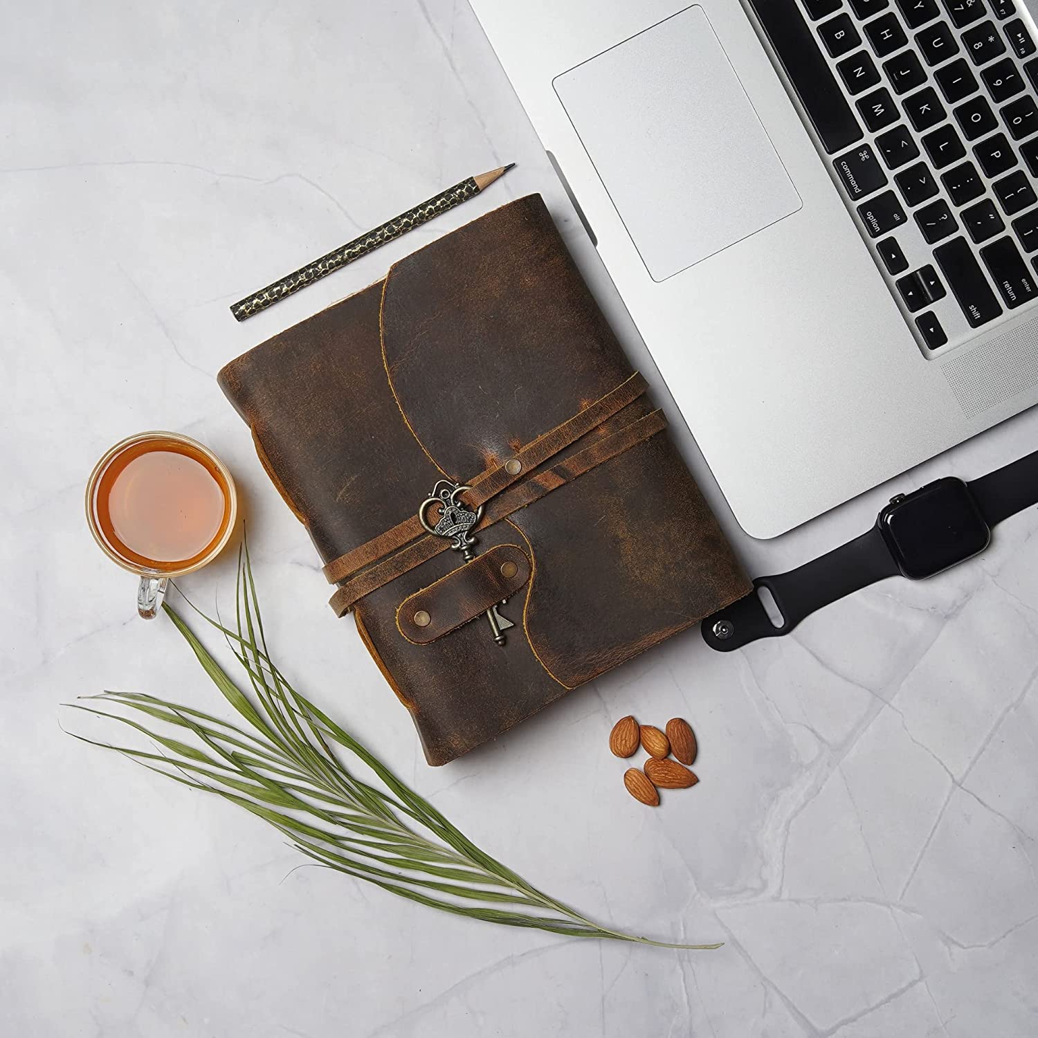 A brown leather vintage journal with key on a desk.