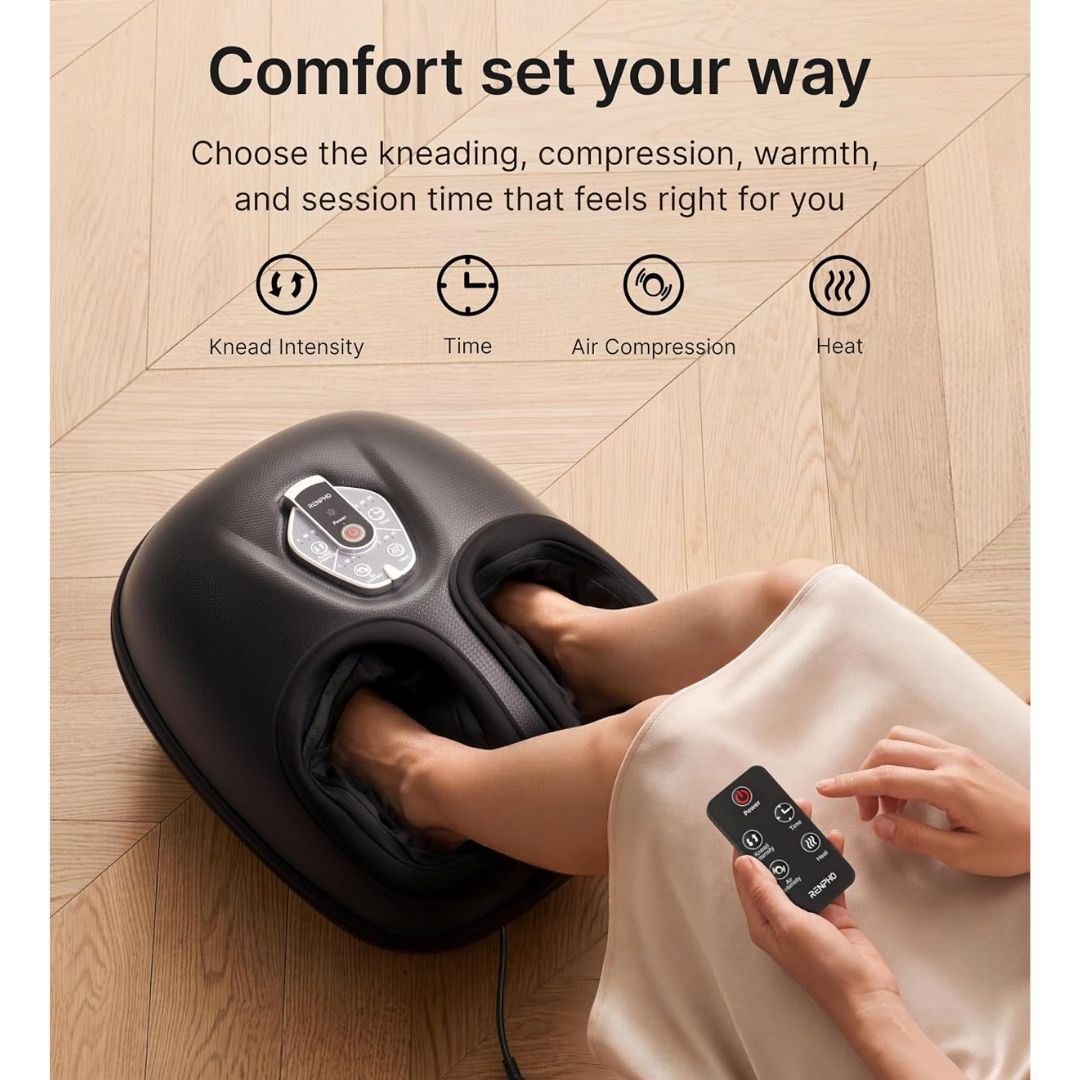 A black foot massage machine shown in use with a person's feet inside the foot cups, on a light wood floor. The image includes marketing text and feature icons for kneading intensity, time, air compression, and heat.