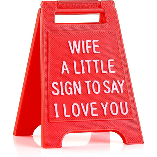 A red plastic A-frame sign with white raised text reading 'WIFE A LITTLE SIGN TO SAY I LOVE YOU' on a clean white background.