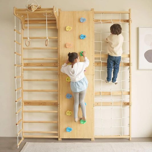 Children playing on a wooden indoor climbing wall gym in a room.