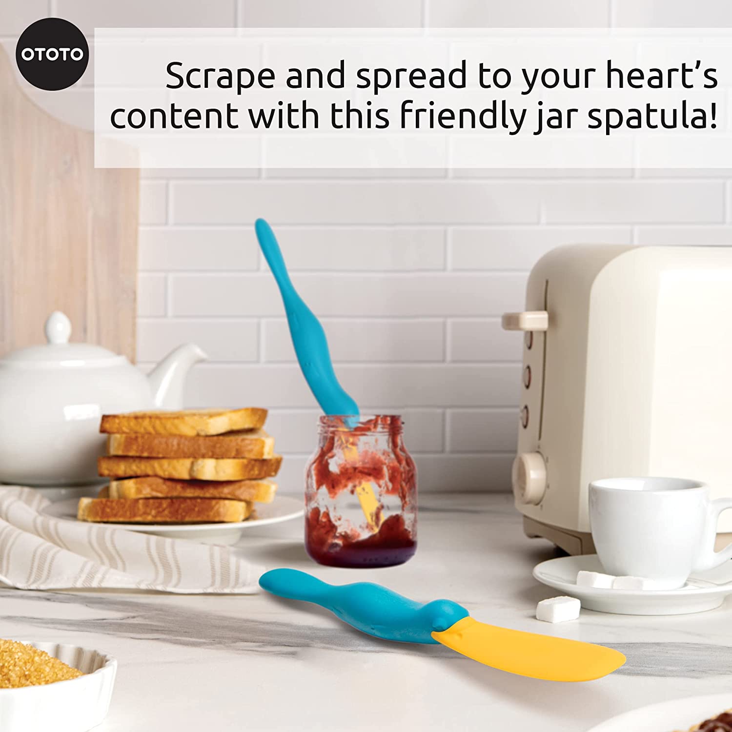 A kitchen scraper spatula in resting in a jam jar on a kitchen bench.