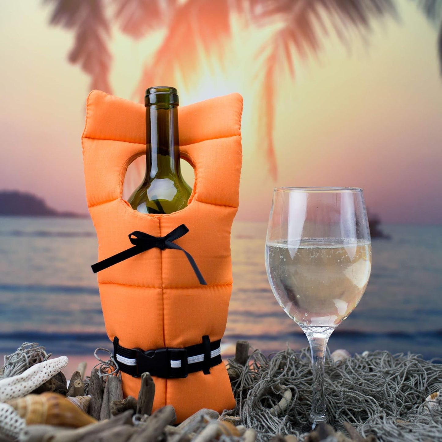 Wine bottle in an orange life jacket cover with a glass of white wine, set against a tropical sunset and ocean backdrop.