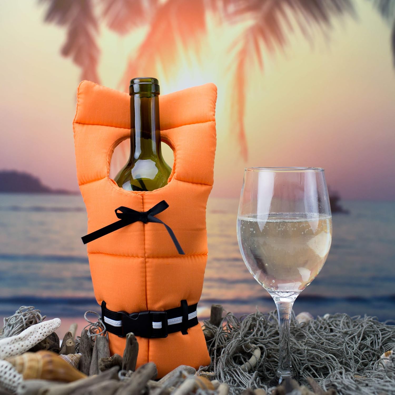 Wine bottle in an orange life jacket cover with a glass of white wine, set against a tropical sunset and ocean backdrop.