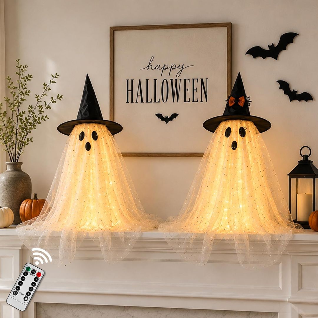Set of two light-up ghost decorations wearing witch hats on a Halloween mantel with remote control