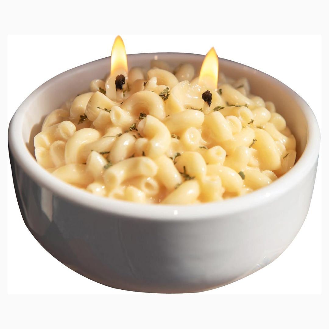 Candle shaped like a bowl of macaroni and cheese with flames on a white background