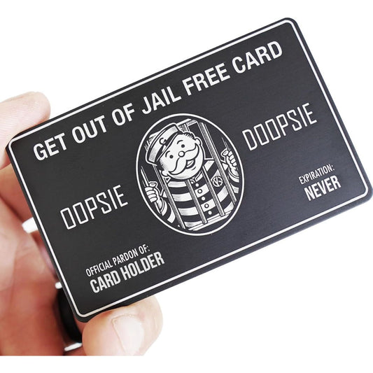 A novelty jailhouse card held in a hand against a white background. The card is black with white text reading 'GET OUT OF JAIL FREE CARD', 'OOPSIE', and 'OFFICIAL PAROLE OF: CARD HOLDER', plus a cartoon parole officer illustration.