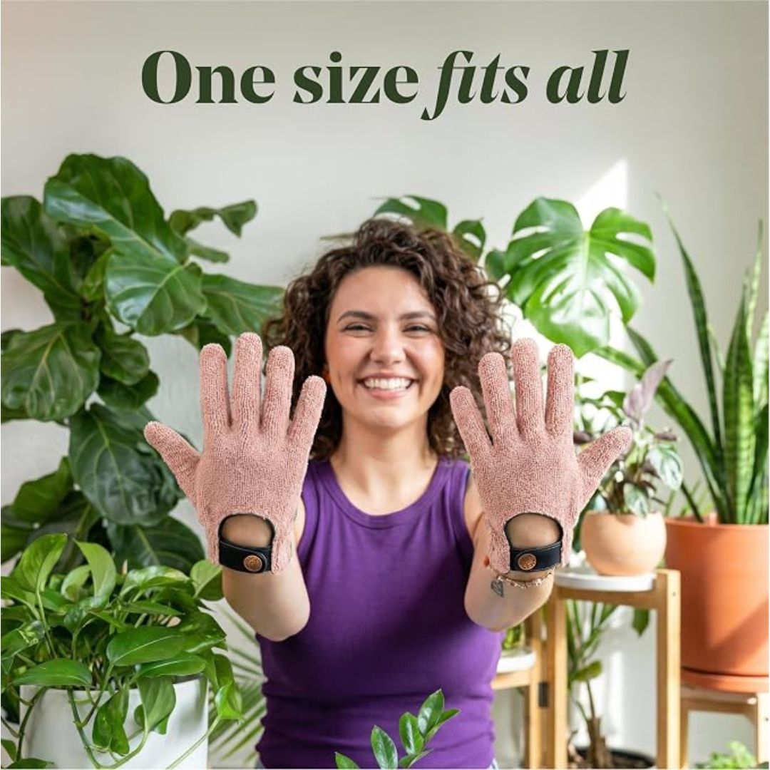 A smiling woman is wearing a pair of microfiber house plant cleaning gloves with text that reads, 'One size fits all'