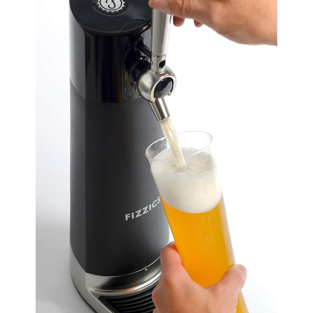 A hand holding a beer glasse and pouring a beer from a nitro style beer dispenser tap