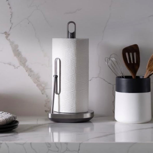 Stainless steel paper towel holder with built-in cleaner spray pump on a kitchen countertop