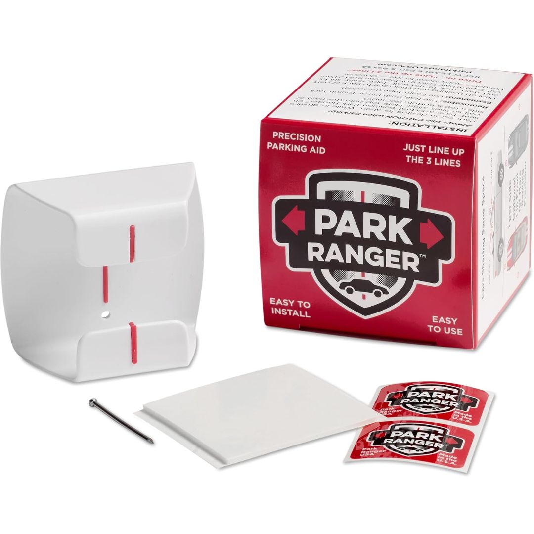 White Park Ranger precision parking aid box with its red and white retail box, installation accessories including a metal pin, a white square pad, and two red-and-white sachets on a white background.