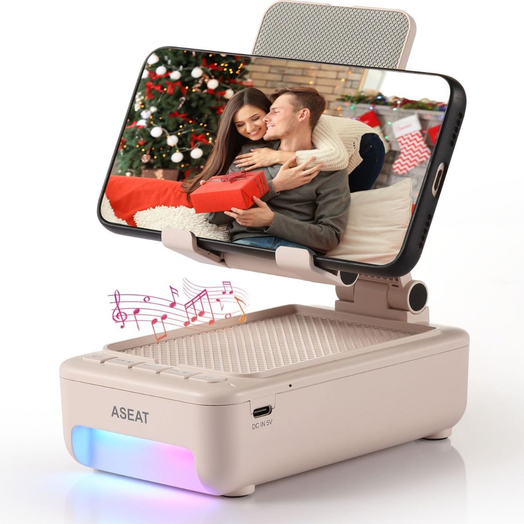 Portable phone stand with phone displaying a couple with a gift, surrounded by festive decorations on screen.