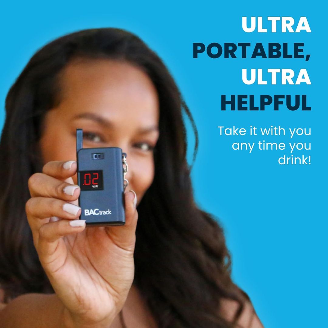 A woman holds up a small black BACtrack portable alcohol test device with a digital display showing '0.2'.