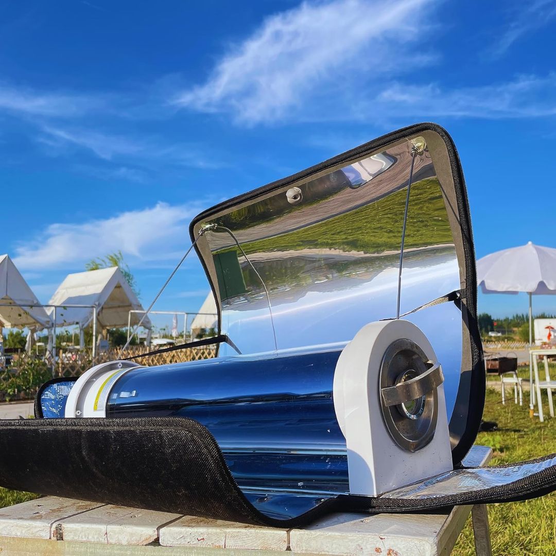 A portable solar oven outdoor cooking device in an outdoor sunny setting