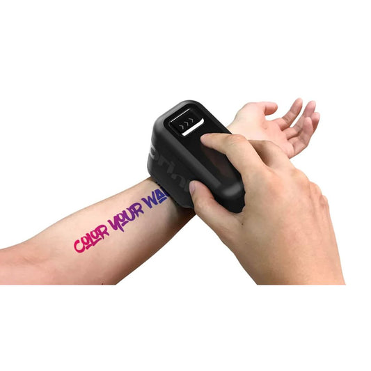 A pair of hands using a portable temporary color tattoo printer on their arm