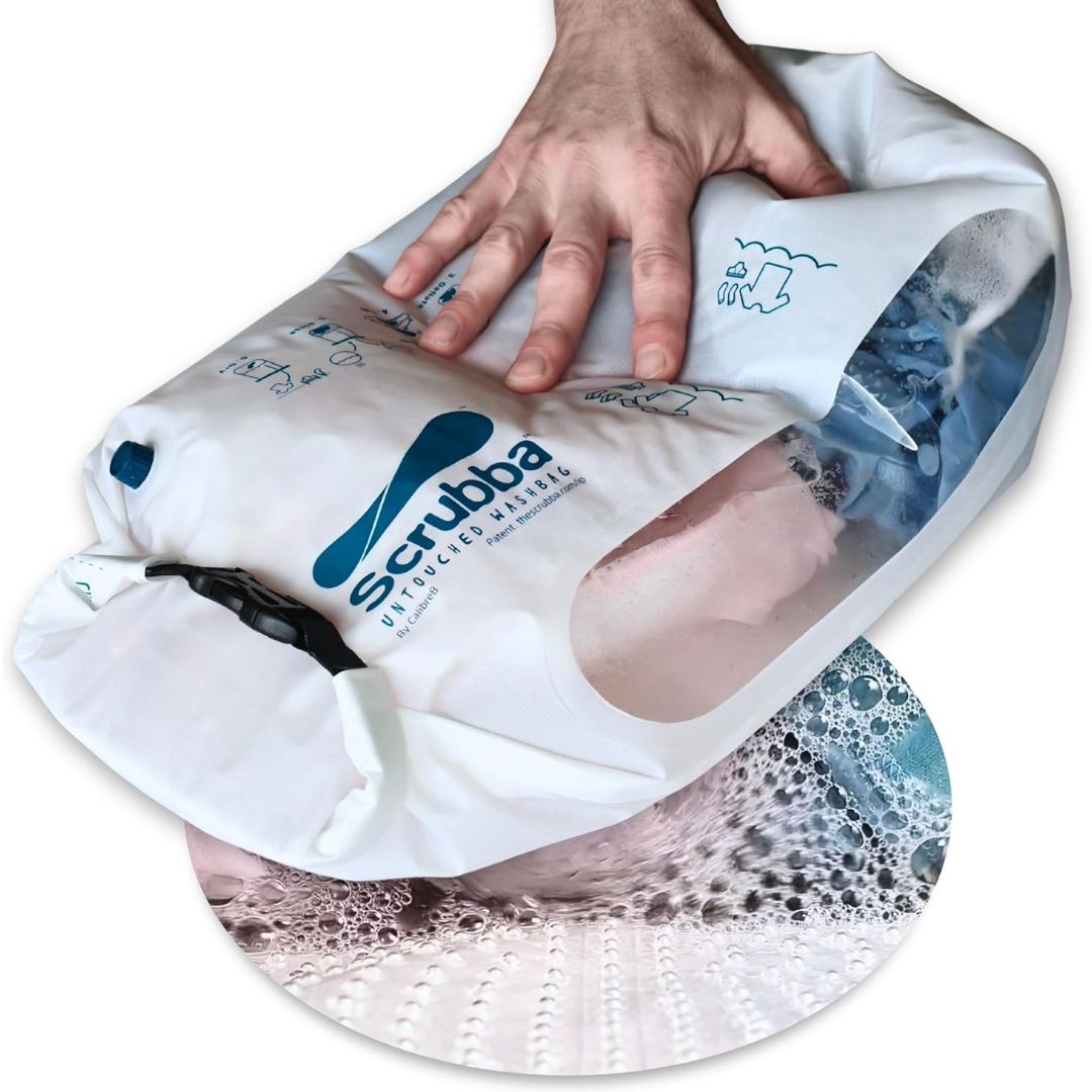 A hand using a portable laundry washing bag