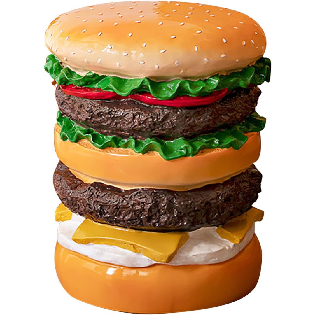 A novelty hamburger stool or shaped like a double-decker burger with sesame buns, lettuce, beef patties, cheese, and tomato on a plain white background.