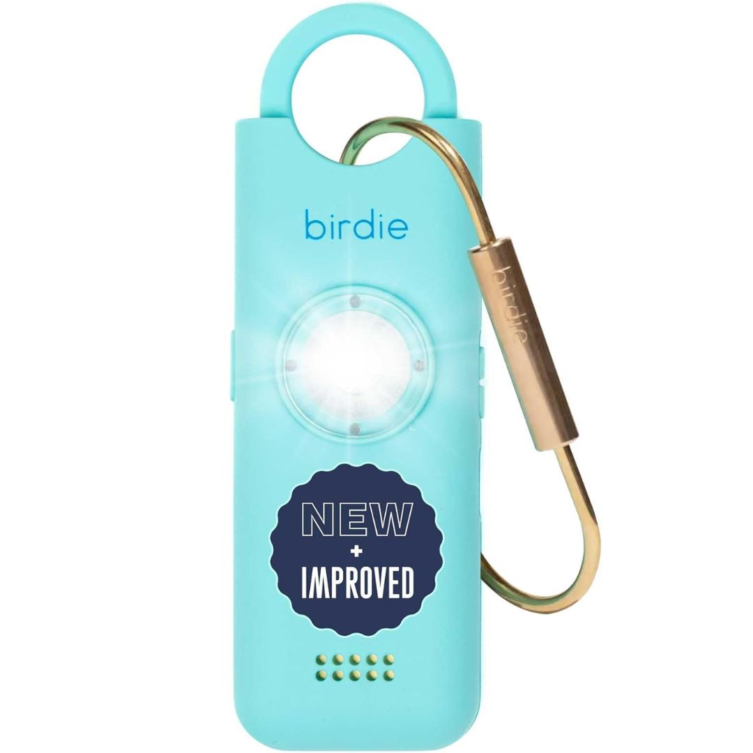 A light blue Birdie personal safety alarm keychain with a built-in LED light, a gold carabiner clip, and a dark blue 'NEW IMPROVED' badge on the front, shown against a plain white background.