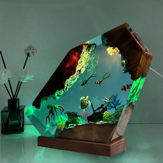Decorative aquarium with underwater scene inside a wooden frame on a reflective surface.